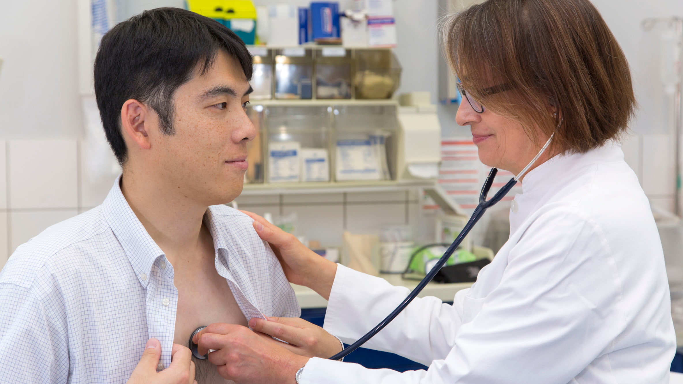 Docteure auscultant la poitrine d'un patient dans une clinique